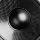 Close-up of a black speaker cone with a textured surface and a central dome.