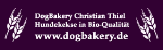 DogBakery-Logo mit Bio-Hundekeksen und Website www.dogbakery.de auf lila Hintergrund.