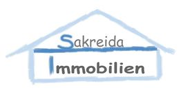 Logo mit einem Hausumriss. Text: "Sakreida Immobilien" in Blau und Grau.
