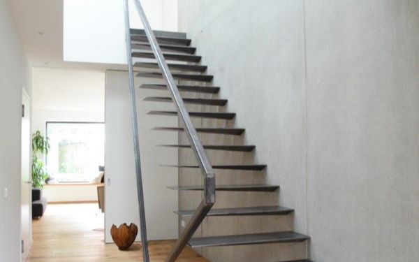 Stahltreppe an einer Wand in Betonoptik.