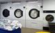 Industrial laundry machines with towels and linens in a laundry facility.