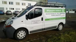 Lieferwagen mit Werbung für Altpapier-Ankauf in Berlin, geparkt vor einem Gebäude.