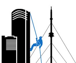 Ein Arbeiter seilt sich von einem Hochhaus ab, daneben ist ein Mast mit Seilen zu sehen.