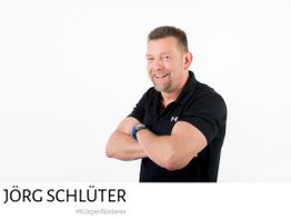 Mann mit schwarzem Polohemd, verschränkten Armen, lächelt, schwarzer Text "Jörg Schlüter".