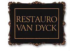 Cartel negro con borde decorativo dice "Restauro Van Dyck" en letras doradas.