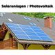 Solarpaneele auf Hausdach mit Schornstein und Dachfenstern, Titel "Solaranlagen/Photovoltaik".
