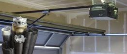 Garage door opener mechanism with coils and motor on the ceiling.