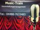 Ein Mikrofon vor rotem Vorhang, darüber steht "Music-Train Veranstaltungsmanagement".
