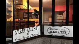 Vetrina di un negozio di interni, con insegne "Arredamenti Marchesi" e "Consulenza d'Interni".