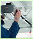 Person installing or adjusting a garage door opener mechanism.