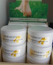 Envase de crema para pedicura Dermoder en estante, con imagen de pie sobre césped.