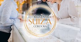 Personas en joyería Relojería Suiza Córdoba, mirando joyas en el mostrador.