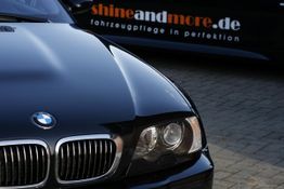 Schwarzer BMW mit glänzender Oberfläche, Schriftzug "shineandmore.de" im Hintergrund.