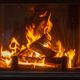 Open haard met brandend hout en vlammen, geplaatst in een stenen muur.
