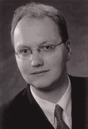 Porträt eines Mannes mit Brille in Schwarz-Weiß, im Anzug.
