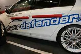 Weiße Autotür mit rotem Türschutz und Schriftzug "doordefender".