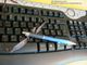 Brille und Stift auf schwarzer Tastatur, im Hintergrund ein gelber Bildschirmrand.