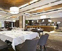 Elegant restaurant interior with a set dining table and modern decor.