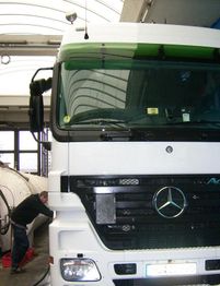 Ein Mann arbeitet neben einem weißen Lastwagen in einer Garage.