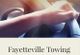 Hand on steering wheel with "Fayetteville Towing" text below.