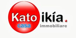 Logo di un'agenzia immobiliare con scritta "Katoikía casa immobiliare" su sfondo bianco.