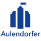 Blaues Gebäude-Icon mit Fahne, darunter der Schriftzug "Aulendorfer".