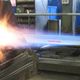 Getto di plasma in un'officina metalmeccanica. Energia luminosa e scintille visibili.
