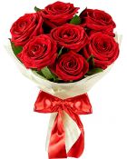 Bouquet of red roses wrapped in white paper with a red ribbon.