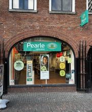 Gevel van een Pearle opticienwinkel in een bakstenen gebouw, met diverse posters en logo's.