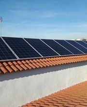 Paneles solares en un tejado de tejas bajo un cielo despejado.