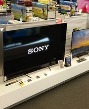 Televisori Sony esposti in un negozio di elettronica, con vari modelli su uno scaffale bianco.