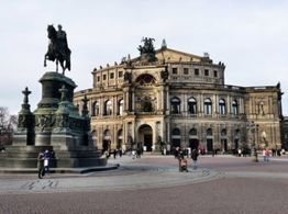 Semperoper Dresden und Reiterdenkmal bei Tag, Menschen auf dem Platz im Vordergrund.