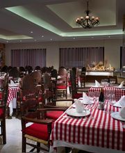Restaurante elegante con mesas de manteles a cuadros rojos y blancos, sillas de madera oscura.