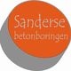 Oranje cirkel met tekst "Sanderse betonboringen" in grijs en wit, op een grijze achtergrond.