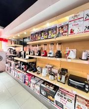 Estante con diversos electrodomésticos de cocina expuestos en cajas y al aire.