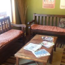 Cozy room with wooden benches, a table with magazines, and colorful wall posters.