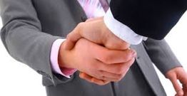 Homens de terno apertando as mãos, simbolizando um acordo ou parceria de negócios.