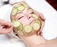 Woman relaxing with cucumber slices on her face at a spa.