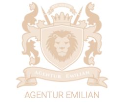 Ein beige Wappen mit einem Löwenkopf, umgeben von Verzierungen, darunter steht "Agentur Emilian".