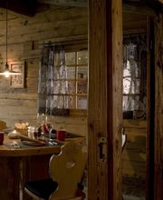 Gemütliches Holzinterieur eines Restaurants mit gedecktem Tisch und dekorativer Beleuchtung.