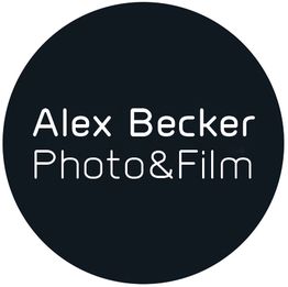 Schwarzer Kreis mit weißer Schrift „Alex Becker Photo&Film“.