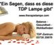 Frau unter Wärmelampe, Text: "Ein Segen, dass es diese TDP Lampe gibt", mit Kontaktinfo.
