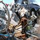Pile of scrap metal and junk, including a bike wheel and damaged car parts.