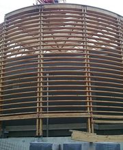 Runde Holzkonstruktion mit Lattengerüst auf Baustelle, unfertiger Zustand.