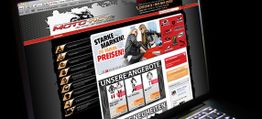 Laptop zeigt eine Motorrad-Website mit Angeboten und Markenlogos bei Nachtansicht.