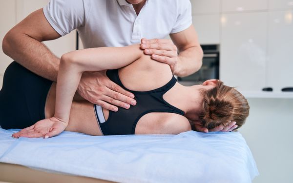 Osteopath behandelt den Rücken einer Frau 