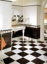 Schwarz-weißer Fliesenboden in elegantem Badezimmer mit Waschbecken und Spiegel.