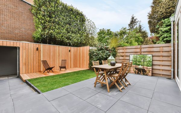 Schön gestaltete Terrasse mit verschiedenen Sichtschutzelementen aus Holz und kleinem Gartentisch. 