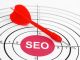 Red dart hitting bullseye labeled "SEO" on target, symbolizing successful search optimization.