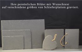 Schieferplatten in verschiedenen Größen, auch in Herzform, auf schwarzem Hintergrund.